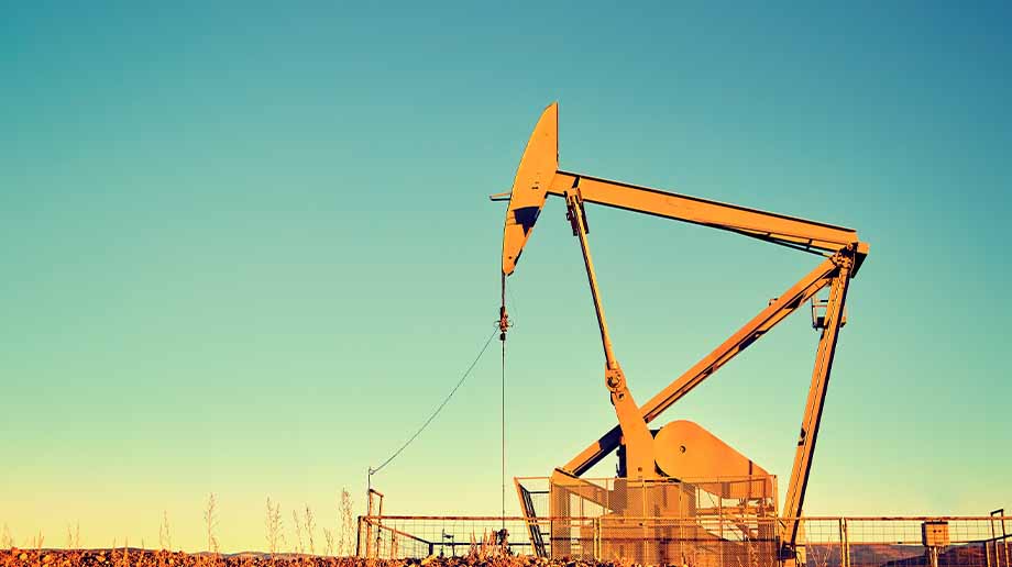 Fenced-in yellow oil pump in the desert