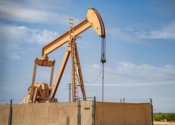 Fenced-in oil pump in field