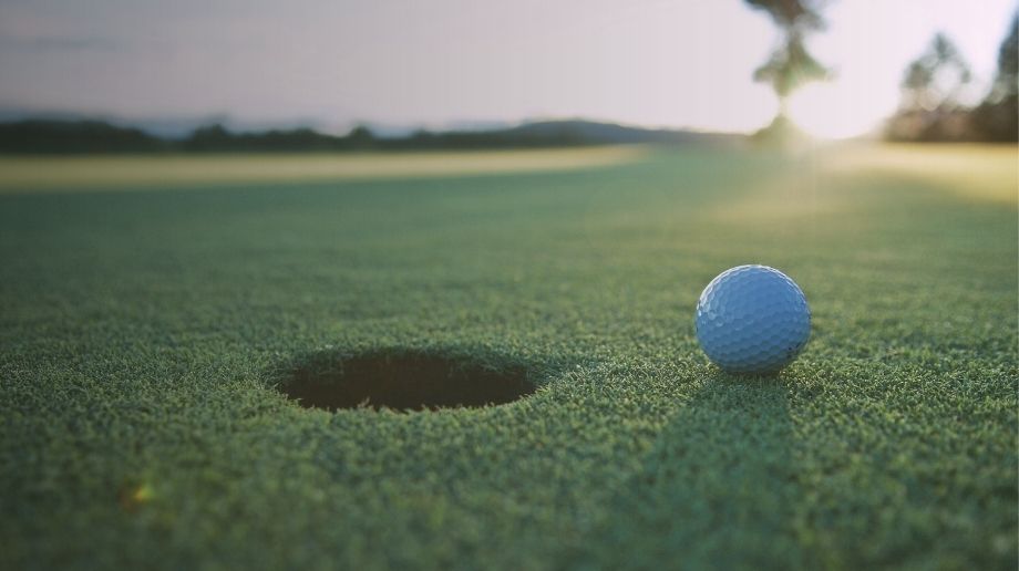 Golf ball next to golf hole