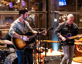 Two men playing guitar on stage