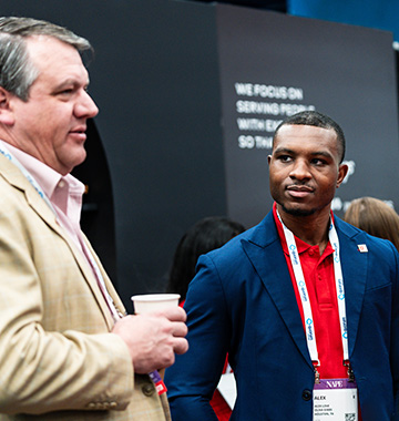 Two men talking at a tradeshow booth