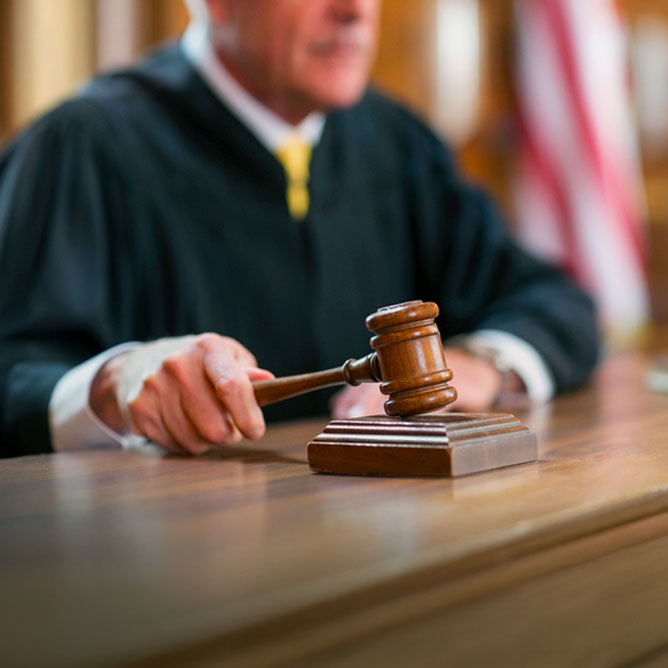 Judge banging gavel in courtroom