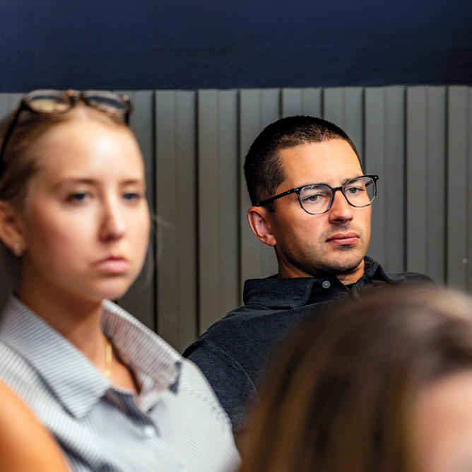 Individuals sitting in room listing to presentation
