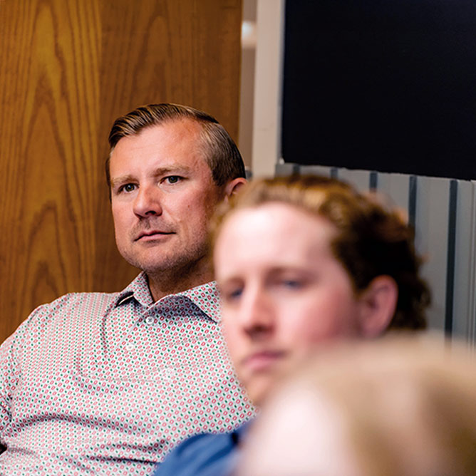 Men sitting in room listening to presentation