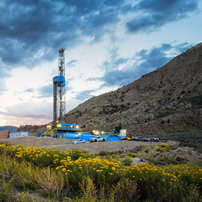 Fracking Drill Rig in a remote location in the mountains with wispy clouds in the sky at dusk