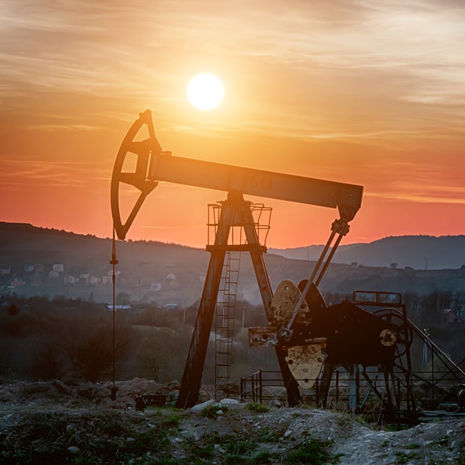 Oil pump in Oklahoma field with sunset backdrop